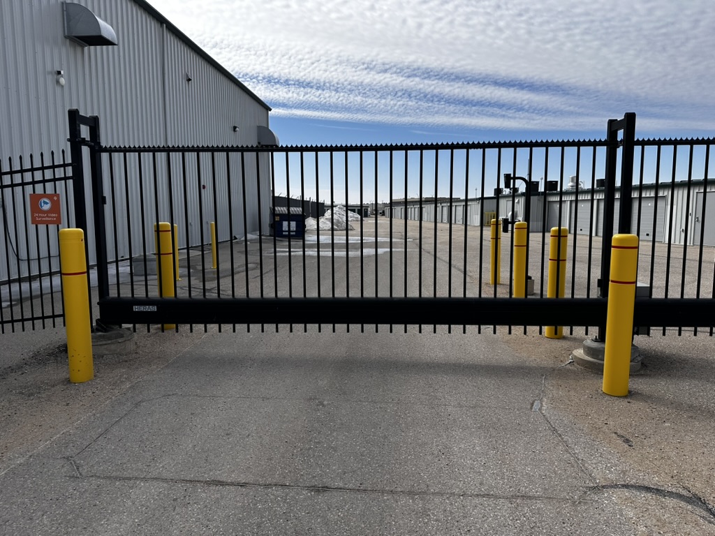 Commercial slide gate with bollards at parking facility