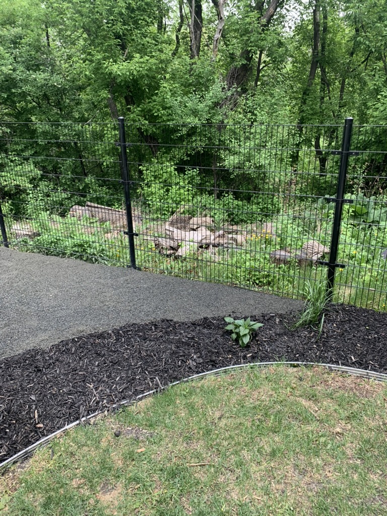 Black welded wire fence in landscaped yard
